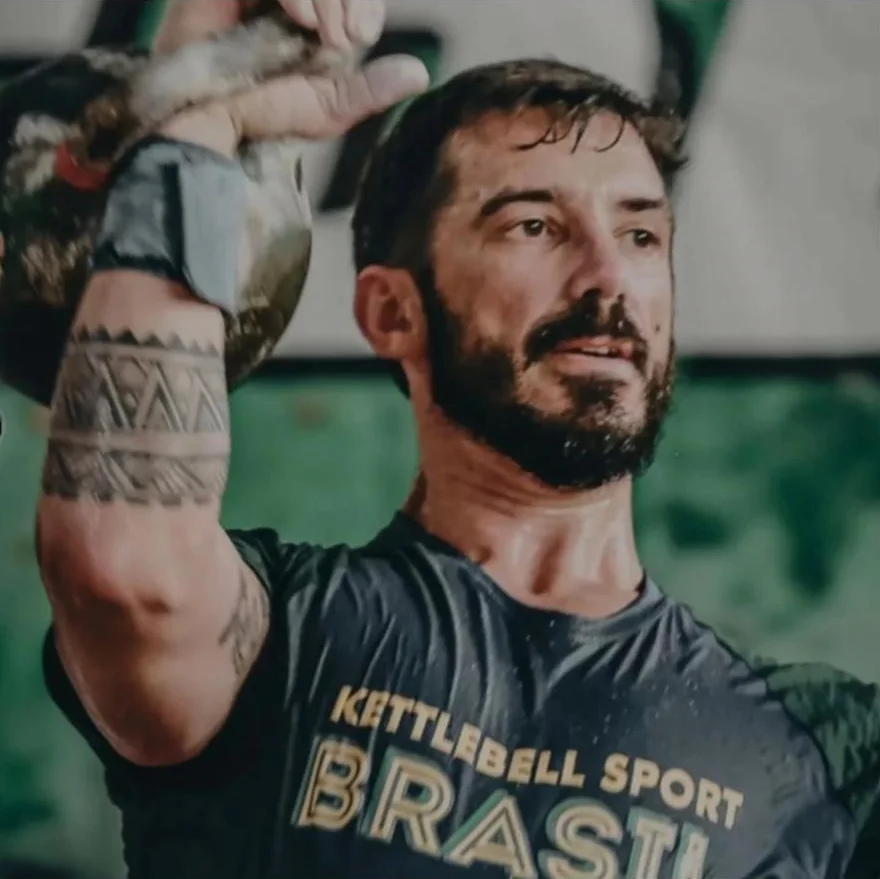 Treinador do UP levantando um kettlebell, de camiseta Kettlebell Sport Brasil